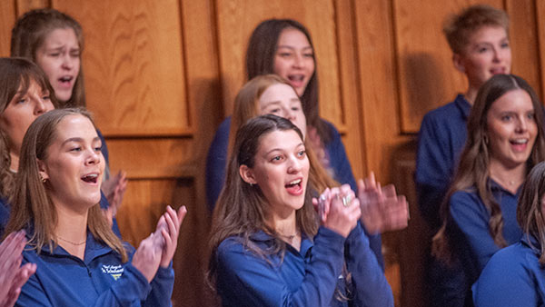 St. Scholastica choir students singing during a Homecoming concert.