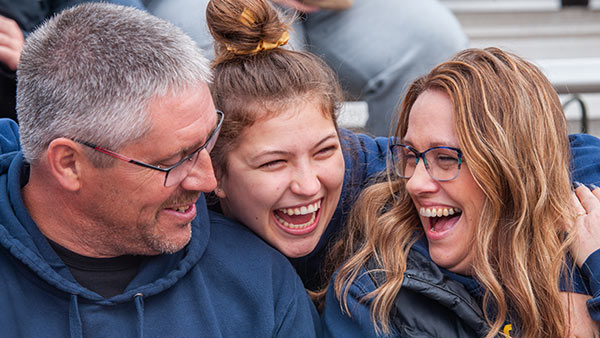 A St. Scholastica student with her parents at the homecoming football game.