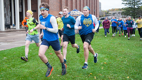 A group of individuals participating in the 5K Walk/Run during homecoming.