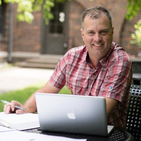 Student studying in the courtyard at St. Scholastica.