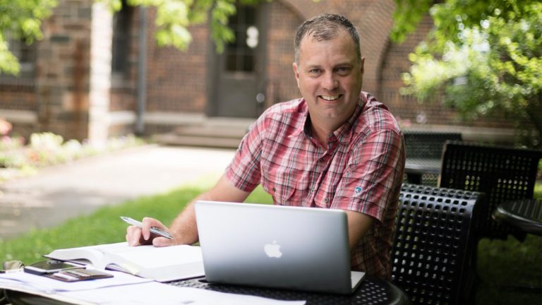 Student studying in the courtyard at St. Scholastica.