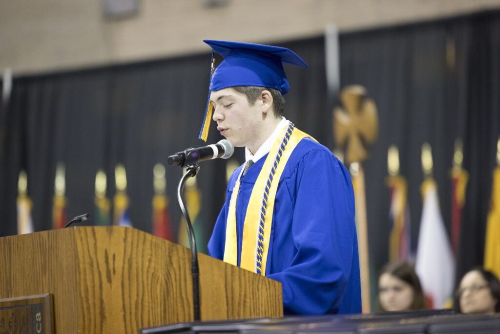 Jason Amireault speaking at podium as one of the commencement speakers.