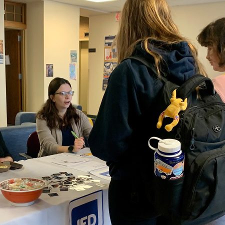 Students stand at a JED Campus table.