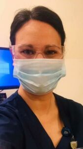 Nurse, Kari Grieman standing at work in her scrubs and mak.