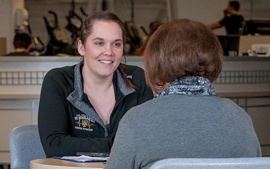 Kaitlin Box provides health coaching to a St. Scholastica employee, Madonna LeBlanc.