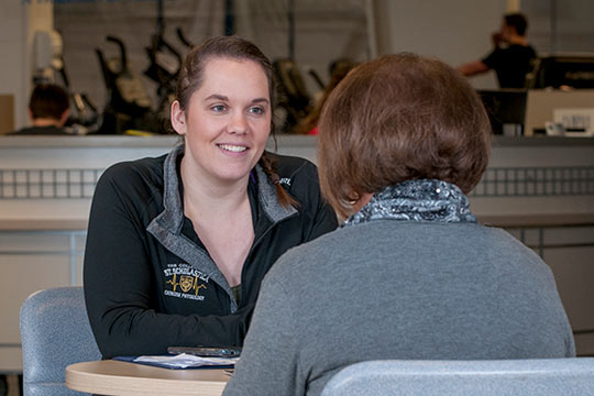 Kaitlin Box provides health coaching to a St. Scholastica employee, Madonna LeBlanc.