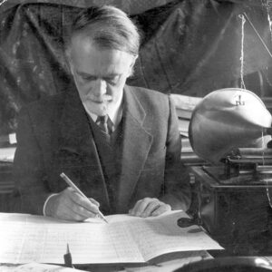 A black and white photo of Zoltán Kodály composing a music score.