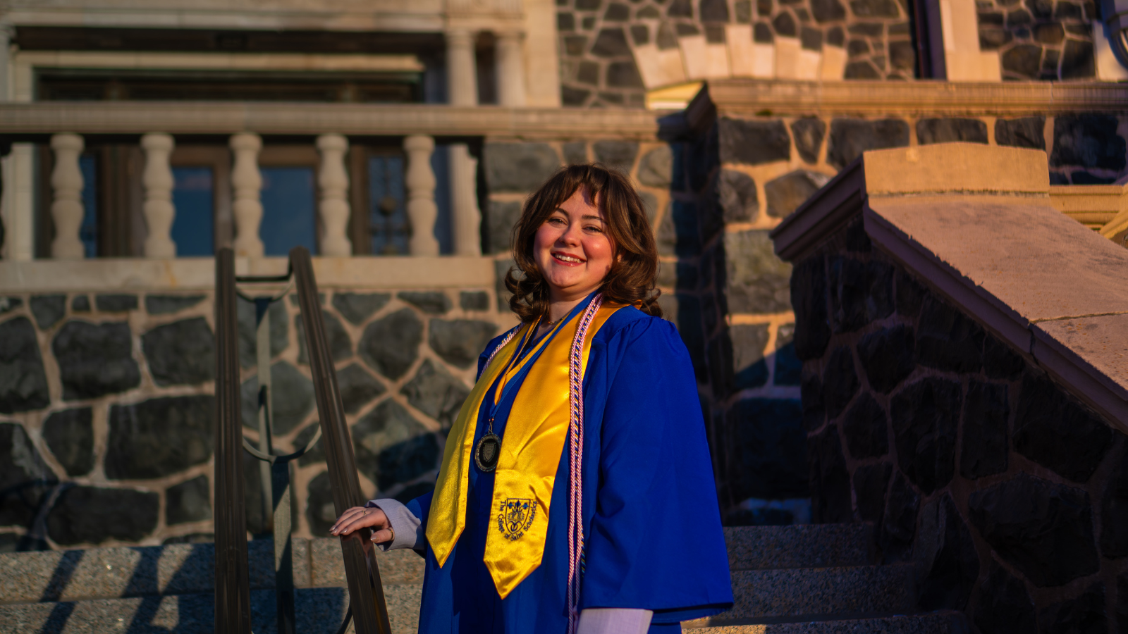 Maddy Ploof in graduation garb in front of Tower Hall.