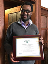 Malvern Madondo holding his Student Employee of the Year award.