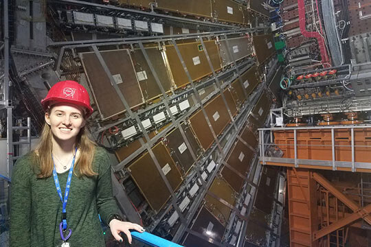 Megan Schiferl next to the ATLAS experiment