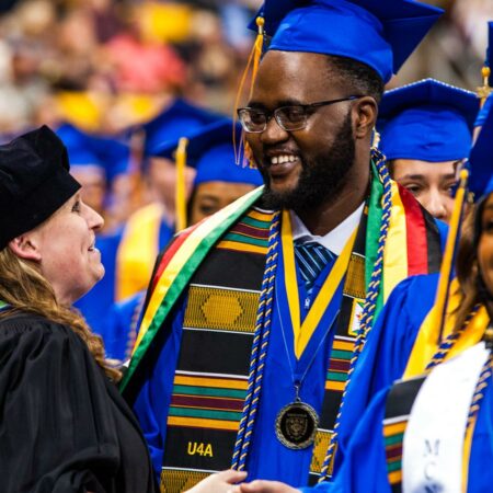 Student greeted by a faculty member at Commencement