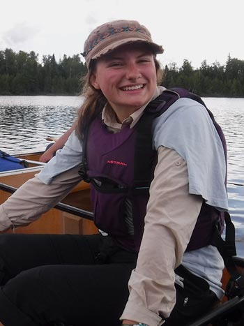 Morgan Mack canoeing on a lake.