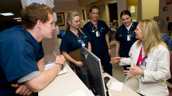 Nursing staff meeting with a supervisor in a hospital setting.