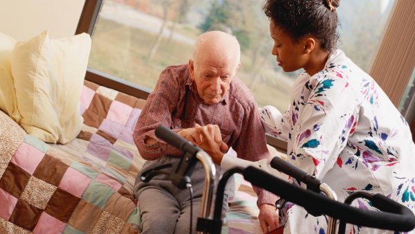 Nursing assistant helping an elderly patient.