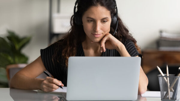 College student listening to an online course lecture on her laptop.