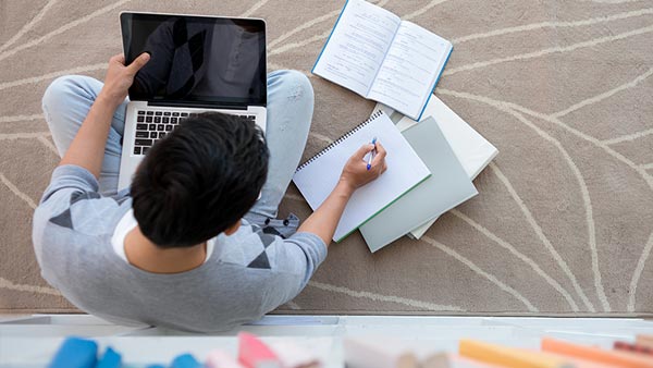 Student completing his studies online using a laptop.