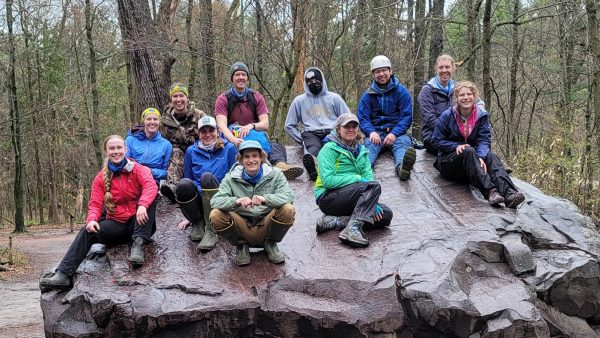 Group of OP Staff posing on a large boulder during a trip.