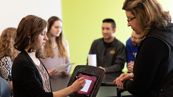 St. Scholastica professor working with OT students in the technologies lab.