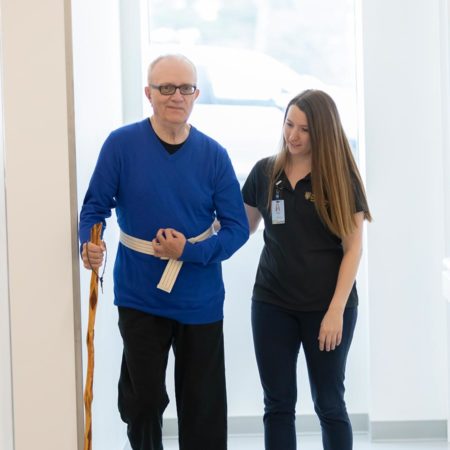 Student assisting a patient during a maurices Clinic physical therapy session.