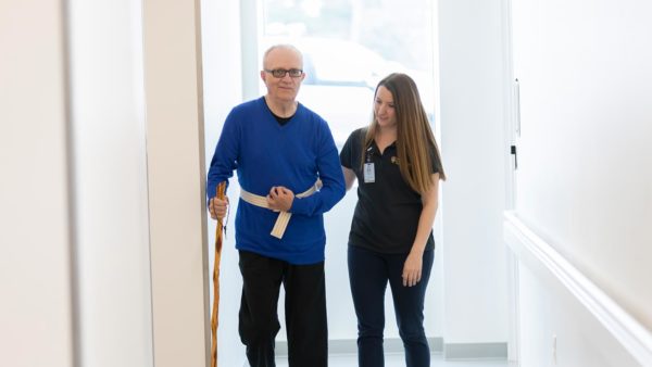 Student assisting a patient during a maurices Clinic physical therapy session.