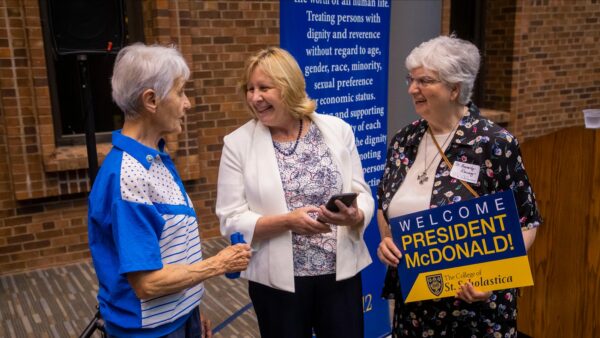 President McDonald talking with two individuals during her welcome reception.