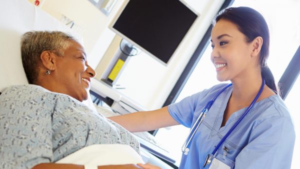 Nurse assisting a patient in a hospital setting.