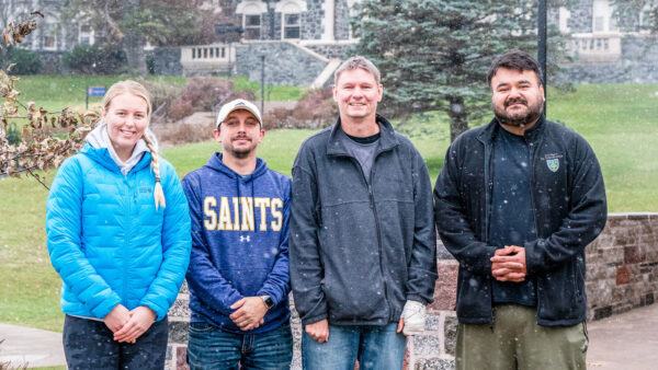 St. Scholastica students standing in front of Tower Hall (left to right: Macy Sunnarborg '24, Jon Whaley '24, Nick Wink '25 and Daryl Baumann '25)