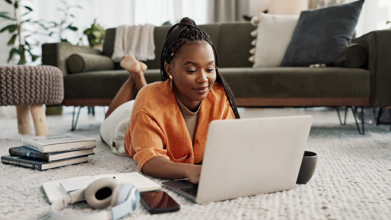 A student at home, filling out a form on a laptop.
