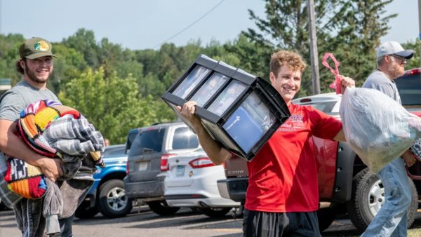 Two students move items into The College of St. Scholastica.