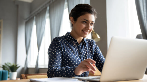 Smiling student working on a laptop.