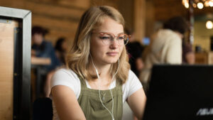 Student studying in a coffee shop on a laptop.