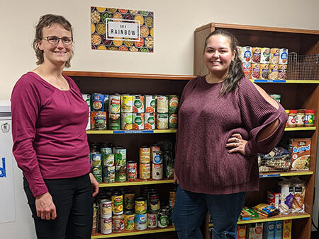 Two St. Scholastica staff members assisting in Storms Cupboard, a student support service.