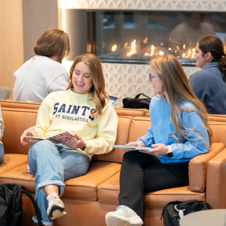 A group of seven St. Scholastica students studying and visiting in the Student Center.