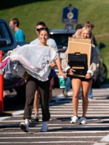 Two students move items into The College of St. Scholastica.
