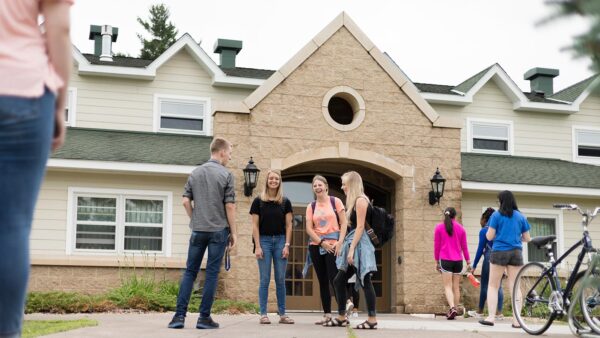 A group of student talking outside upper-class dorms