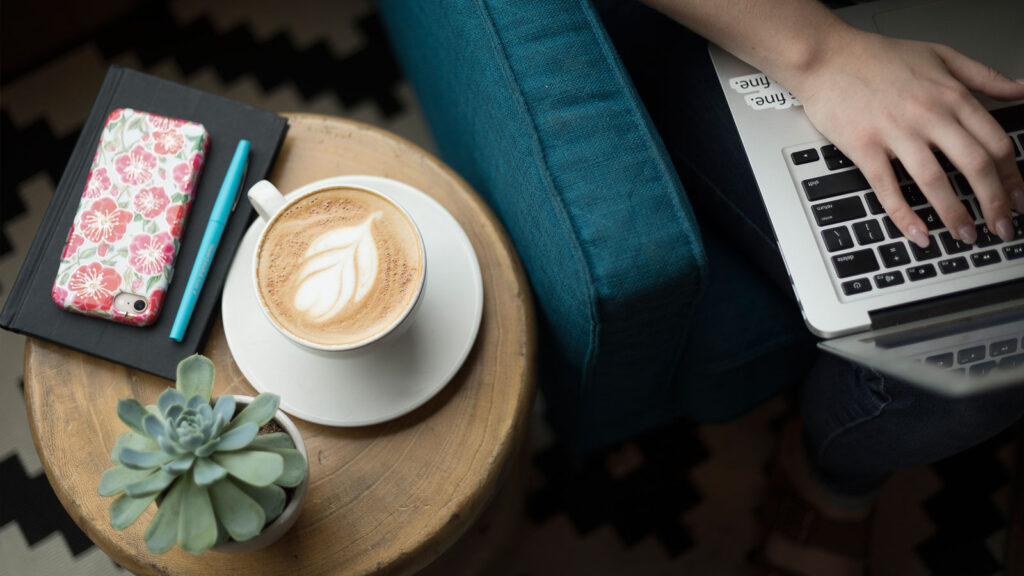 Student working on a laptop in a coffee house.