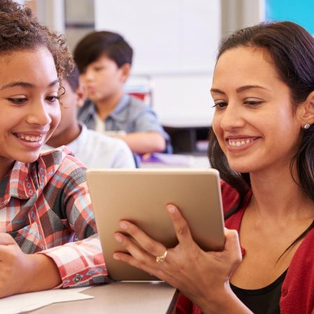 Teacher working with a student in a classroom.