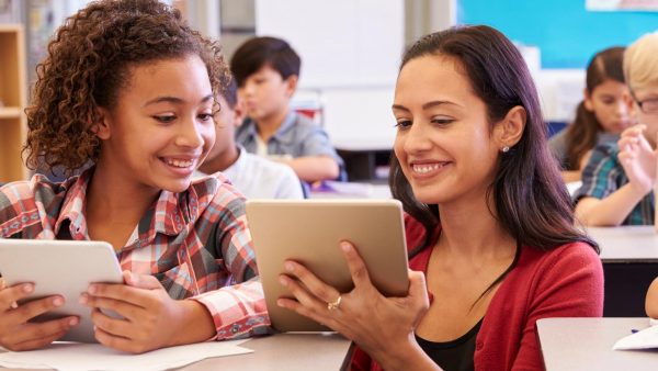 Teacher working with a student in a classroom.