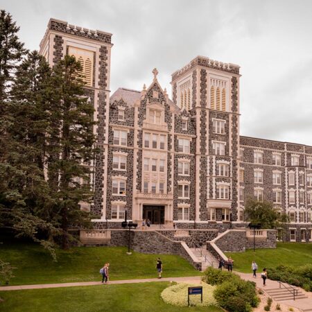 Students walking outside of St. Scholastica's Tower Hall.