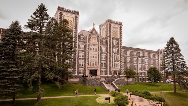 Students walking outside of St. Scholastica's Tower Hall.