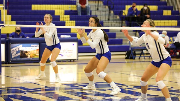 Three St. Scholastica students playing in a volleyball game at the Duluth campus.