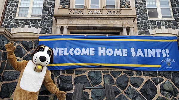 Storm standing in front of Tower Hall, welcoming Saints to Homecoming.